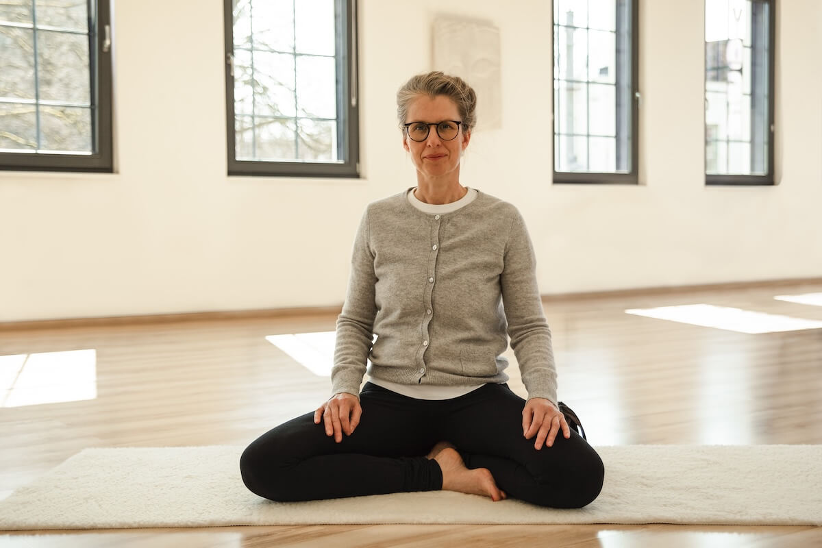 Frau in Shavasana auf Holzboden