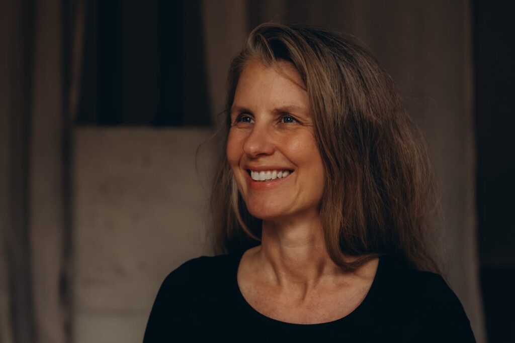 Die Meditationslehrerin Kerstin Rubel sitzt im Studio und lacht.